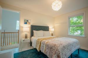 a bedroom with a bed and two windows at Stylish lake home with private beach, dock and firepit for swimming, kayaking, hiking in Barnstead