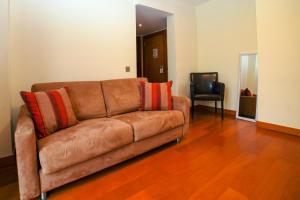 a brown leather couch in a living room with a chair at Eirado Hotel in Caldelas