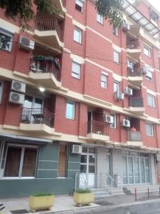 - un grand bâtiment en briques rouges avec balcon et climatisation dans l'établissement IV2020 apartment, à Skopje