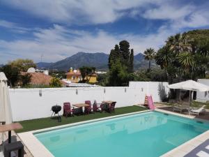 a swimming pool with a table and chairs next to a fence at Marbella别墅独立房带泳池 in Marbella