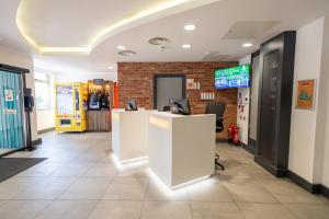 a lobby with a reception desk and a brick wall at easyHotel Croydon in Croydon