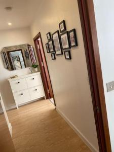 un corridoio con una stanza con un comò e uno specchio di Luxurious 2 bedroom flat with en-suite bedroom a South Norwood