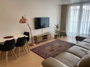 un soggiorno con divano, tavolo e TV di Luxurious 2 bedroom flat with en-suite bedroom a South Norwood