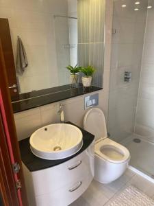 a bathroom with a sink and a toilet at Luxurious 2 bedroom flat with en-suite bedroom in South Norwood