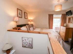 a bedroom with a large bed and a room with a couch at Rusland View in Ulverston