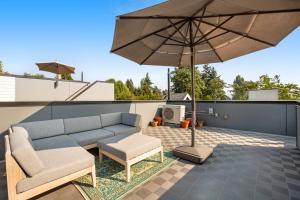 a patio with a couch and an umbrella on a roof at Northlake Nirvana in Seattle
