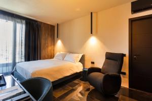 a hotel room with a bed and two chairs at Etrus - Boutique Room & Rooftop in Pontecagnano