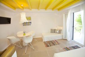 a living room with a table and chairs and a couch at Golden Sun Hotel in Stelida