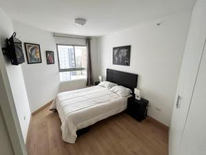 Habitación blanca con cama y ventana en Apartamento exclusivo y céntrico en Lima Moderna, en Lima