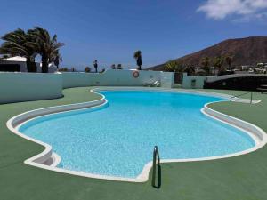 a swimming pool in a resort with a mountain in the background at Mountain View Villa in Playa Blanca
