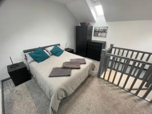 een slaapkamer met een groot bed met blauwe kussens bij 3 bedroom apartment in the village of Whitwell in Worksop