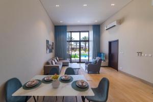 een woonkamer met een tafel en stoelen bij Palm House in Salalah