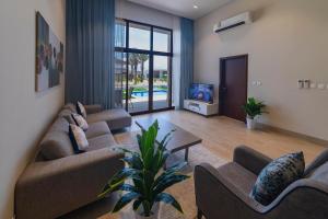 sala de estar con 2 sofás y TV en Palm House en Salalah