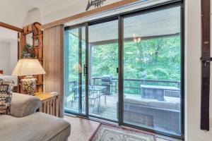 a living room with a sliding glass door leading to a deck at 7 Springs Ski & Mountain Adventure Condo condo in Champion +26 photos