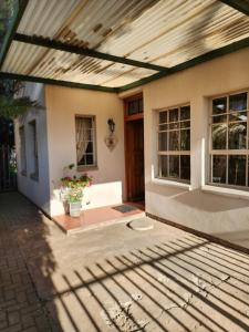 a porch of a house with a wooden ceiling at La Provence Accommodation in Bloemfontein