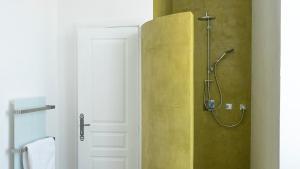 La salle de bains est pourvue d'une douche avec un mur jaune. dans l'établissement Domaine de la Bedosse, à Alès