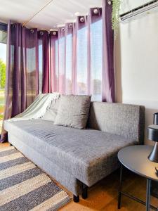 kanapa w pokoju z fioletowymi zasłonami w obiekcie Dom na wodzie LaMare XS 1 w Bydgoszczy