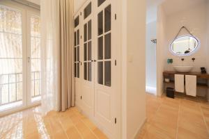 a bathroom with a door with a sink and a mirror at Albariza Hotel Boutique in Sanlúcar de Barrameda