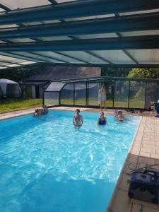un groupe de personnes dans une piscine dans l'établissement La fantasia gîte, à Saint-Sylvain-dʼAnjou