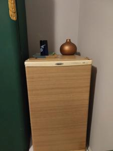 a wooden cabinet with a pot on top of it at Quarto Aconchegante! in Sorocaba