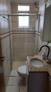 uma casa de banho com um WC, um lavatório e um chuveiro em Quarto Aconchegante! em Sorocaba