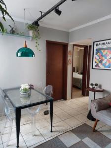 uma sala de jantar com uma mesa de vidro e cadeiras em Quarto Aconchegante! em Sorocaba