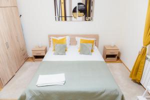 a bedroom with a bed with green and yellow pillows at Free parking Downtown Apartment Boutique Green Garden Unirii in Bucharest
