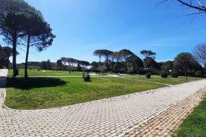 a brick walkway in a park with trees and grass at Super Villa for vacation Gjiri i Lalzit in Draç