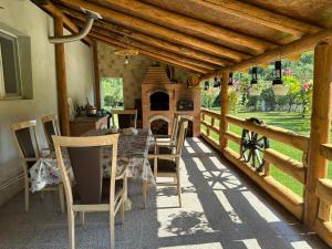 a patio with a table and chairs and a fireplace at Cabana lui Foardă in Motru Sec