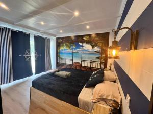 een slaapkamer met een bed en een schilderij van een strand bij Les 5 thèmes in Antoigny