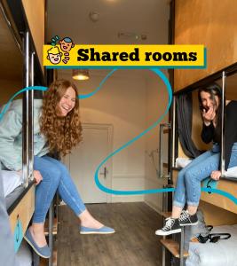 a woman sitting on a bunk bed in a trailer with shared rooms at Leevin Hostel George in Dublin