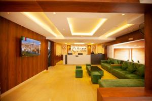 a living room with green couches and a tv at Golden Fortune Inn Hotel in Bengaluru