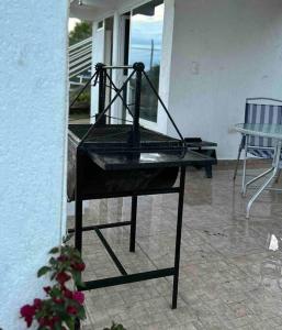a black chair sitting on top of a porch at Casa campestre en Popayán, para descansar, compartir con los tuyos in Popayan