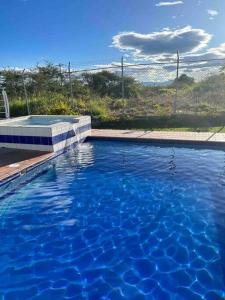 a swimming pool with blue water in a yard at Casa campestre en Popayán, para descansar, compartir con los tuyos in Popayan