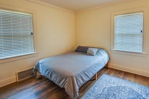 a small bedroom with a bed and two windows at Lexington Condo with Balcony 1 Mi to UK Campus! in Lexington