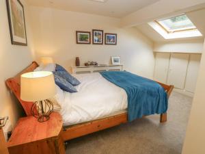 a bedroom with a bed and a lamp on a table at Lee House Farm in Halifax