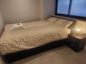 een slaapkamer met een bed met een lamp en een raam bij Entire Reigate Apartment hosted by Pius in Reigate
