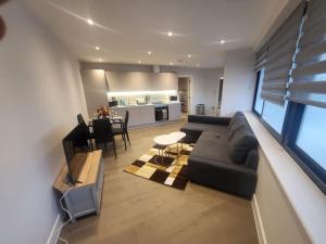 a living room with a couch and a table at Entire Reigate Apartment hosted by Pius in Reigate