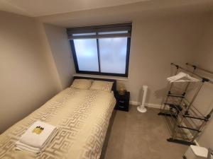 a small bedroom with a bed and a window at Entire Reigate Apartment hosted by Pius in Reigate