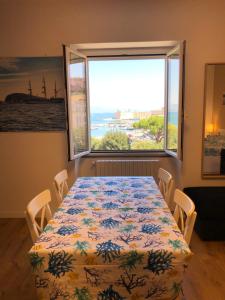 a dining room with a table and a large window at La Finestra sul Mare in Gaeta