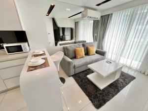 Sala de estar blanca con sofá y mesa en INNER CIRCLE 1 Bed In City Center Residence, en Pattaya central