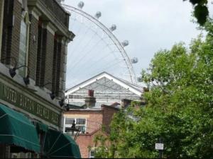 a ferris wheel in the background of a city with buildings at APlaceToStay Central London apartment, Zone 1 DOW in London +2 photos