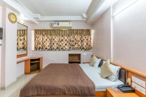 Hotel Sanmati tesisinde bir odada yatak veya yataklar