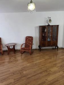 a room with two chairs and a table and a cabinet at Apartament 2 dormitoare in Ploieşti