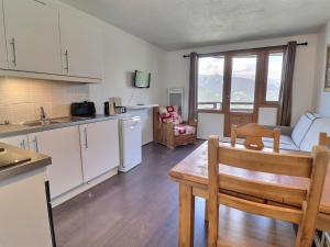 a kitchen and living room with a table and a couch at Appartement La Tania, 2 pièces, 4 personnes - FR-1-182A-5 in Courchevel