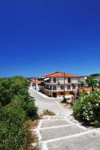 an empty road in a town with a building at Hotel Korakakis Beach in Finikounta