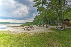 a park with benches and a playground next to a lake at Poconos Getaway with Indoor and Outdoor Pool Access! in Gouldsboro