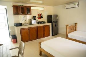 a small kitchen with a refrigerator and a table at Rocky Cay Lodging in San Andrés