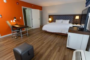 a hotel room with a bed and a desk and a television at Hampton By Hilton San Jose Airport Costa Rica in Alajuela City