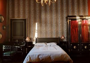 a bedroom with a bed and a chandelier at Le 1825, une suite luxueuse au coeur de la ville in Nantes